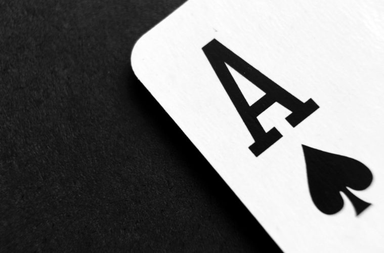 ace of spade playing card on grey surface